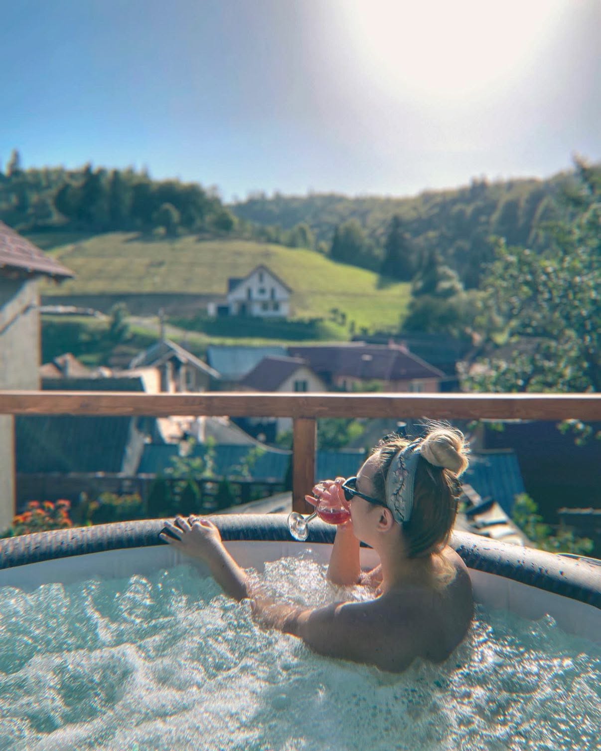 Jacuzzi exterior cu priveliște spre sat și dealuri verzi