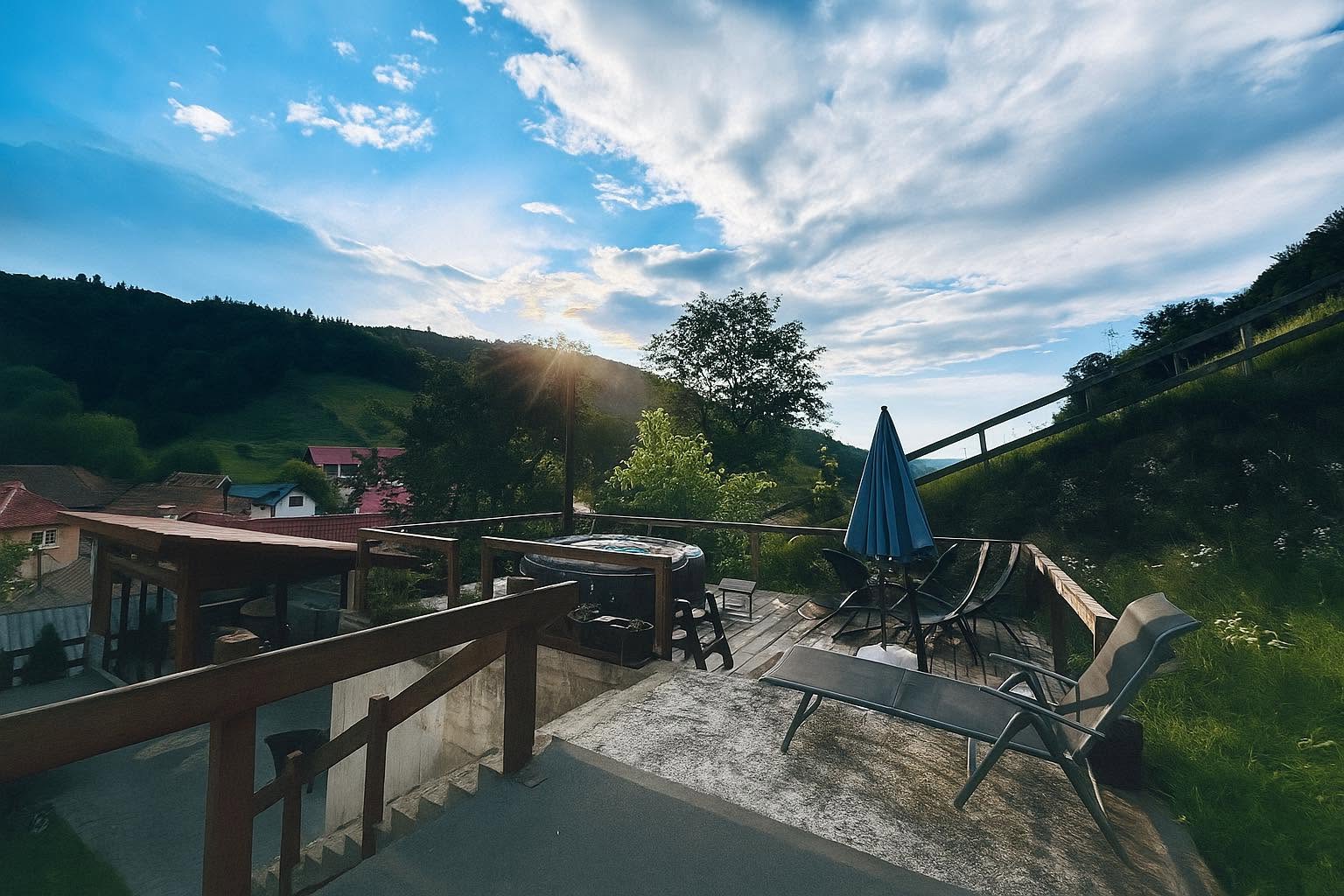 Casa Frătilă — terasă cu jacuzzi și priveliște spre dealurile Holbavului