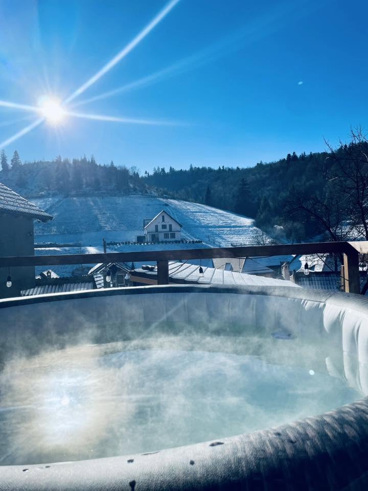 Jacuzzi cu aburi în zi de iarnă însorită