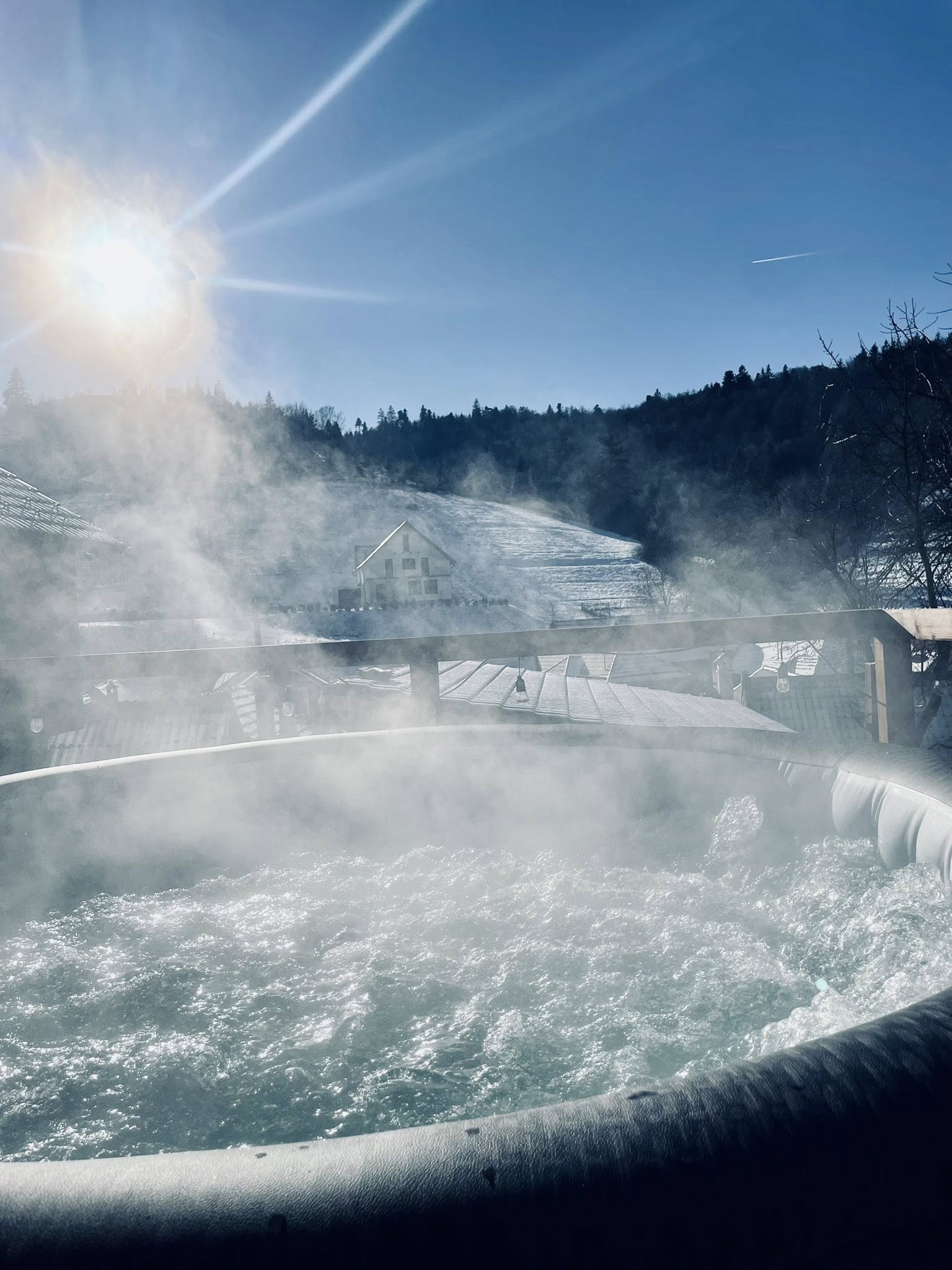 Jacuzzi cu aburi în lumina soarelui de iarnă